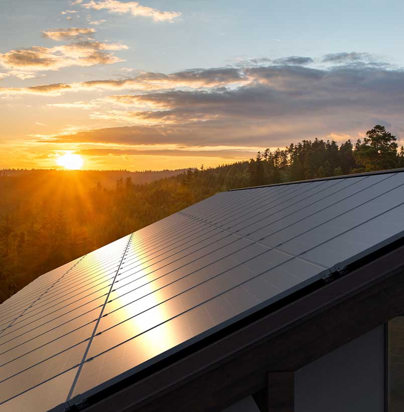 solar-panels-sunset A set of solar panels on a rooftop gleam in the dusk sunlight