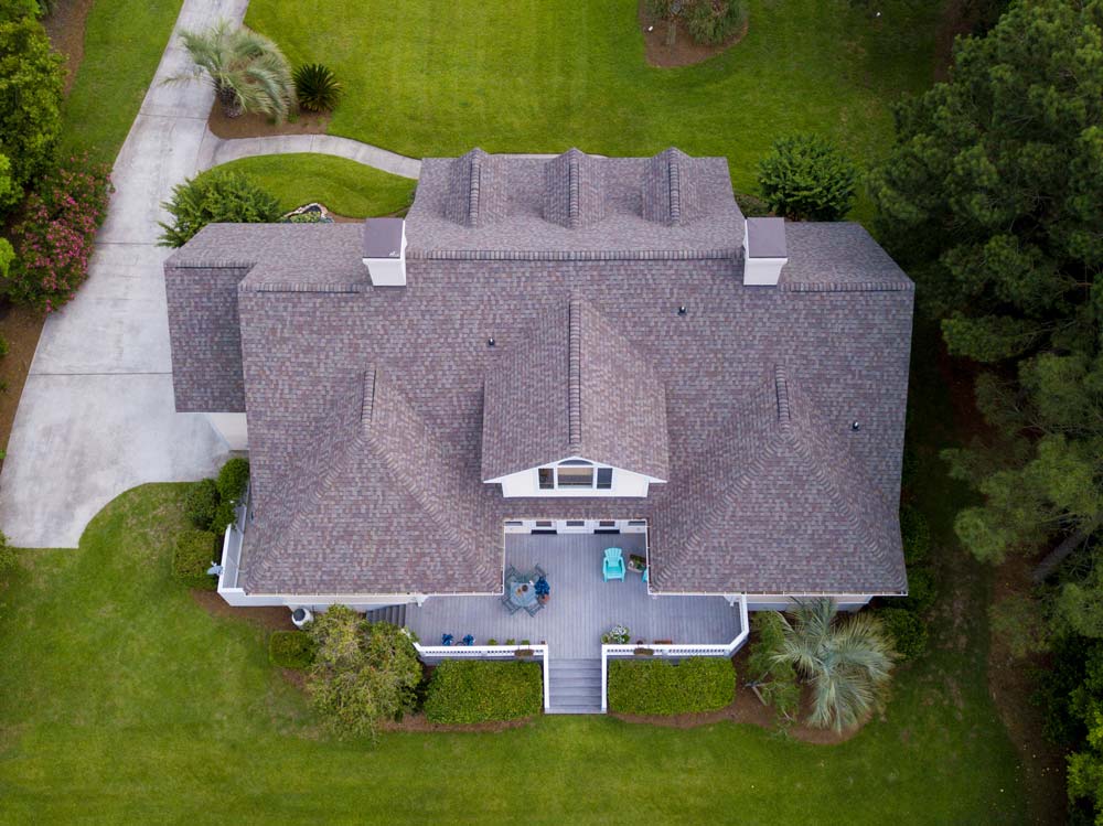 roofing-aerial-view-roof An aerial view of a new roof on a home surrounded by lush grass and trees.