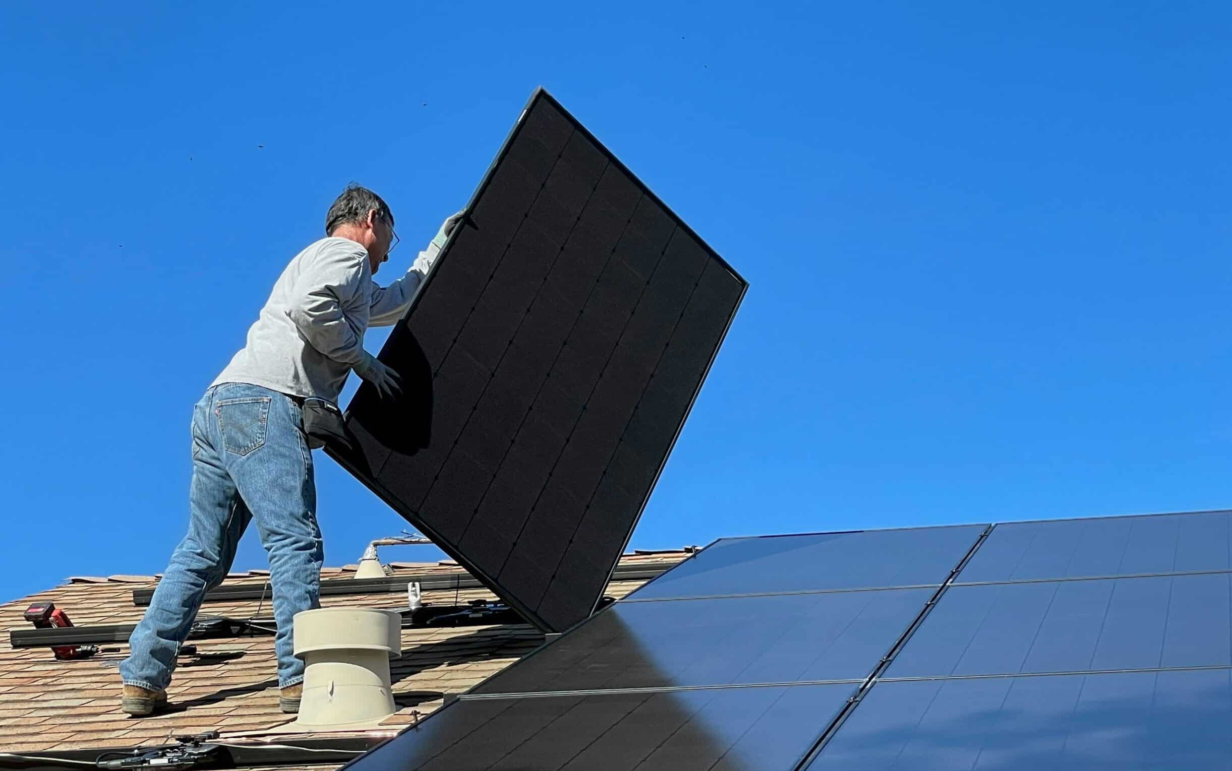 solar-installation-incentive A solar technician installs solar panels on a residential roof.